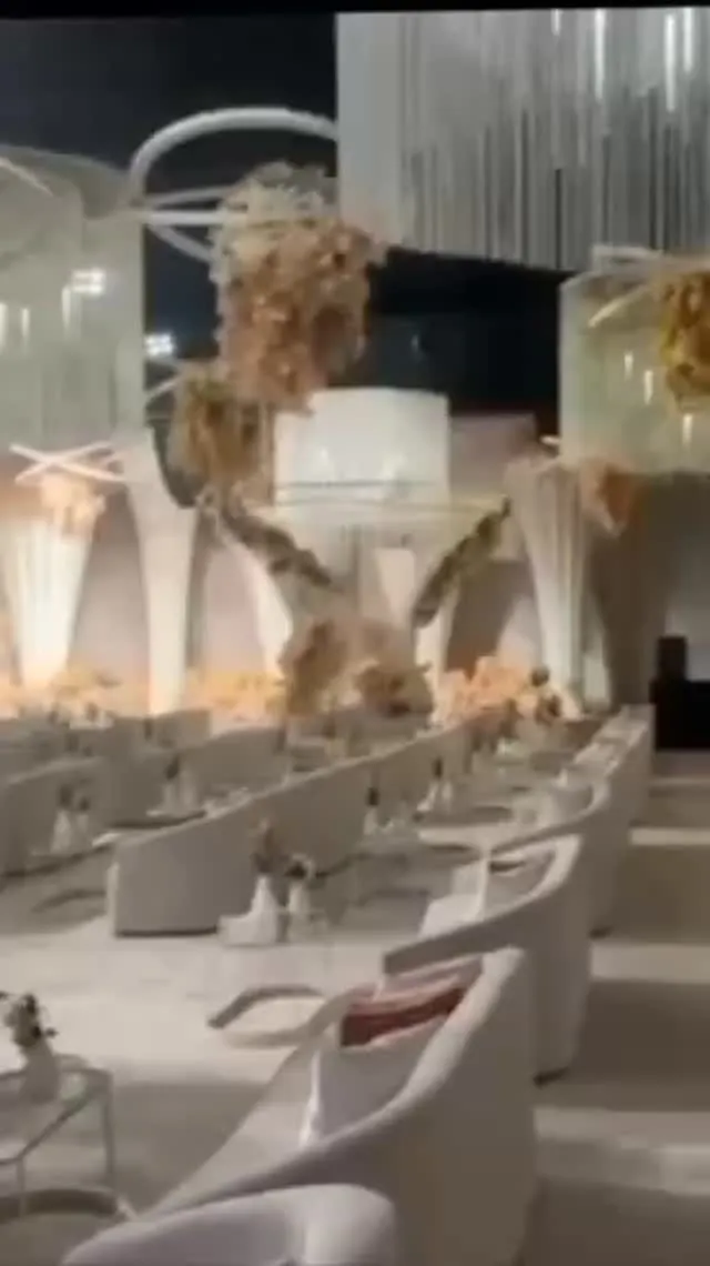 White lounge armchairs with dried floral installations at night